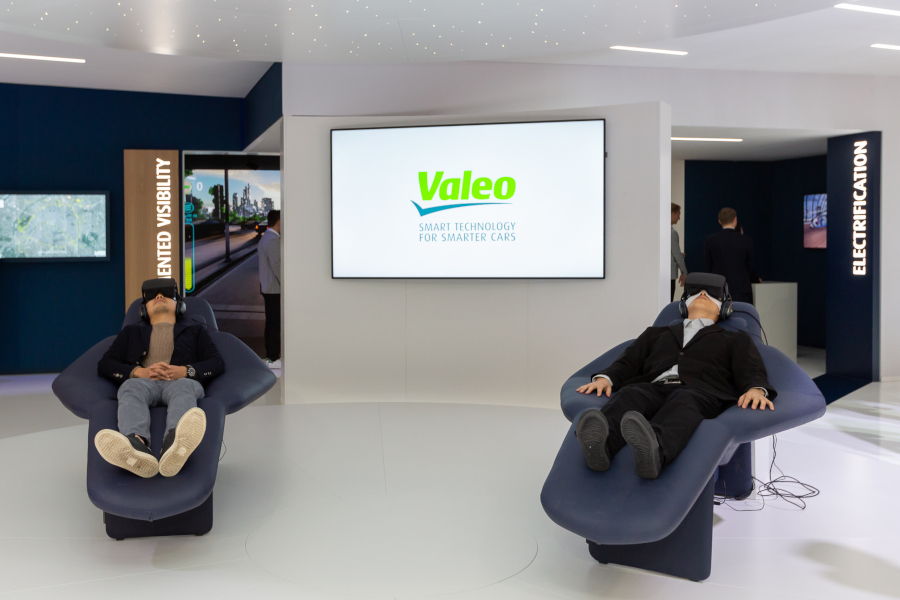 Two people testing virtual reality at a Valeo stand at mondial de l auto 2018 event