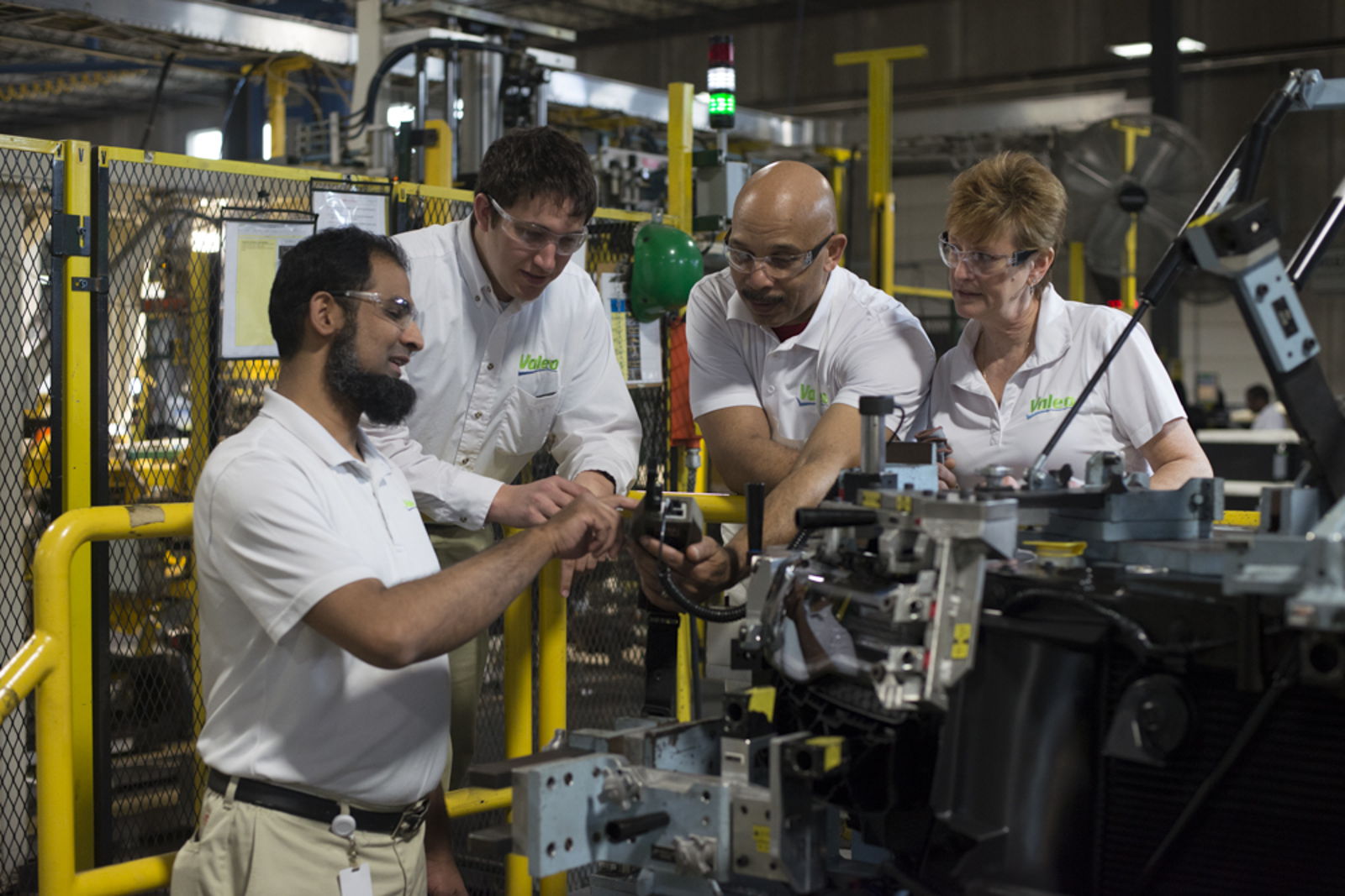 A group of employees inspecting a product at Auburn Hills USA plant