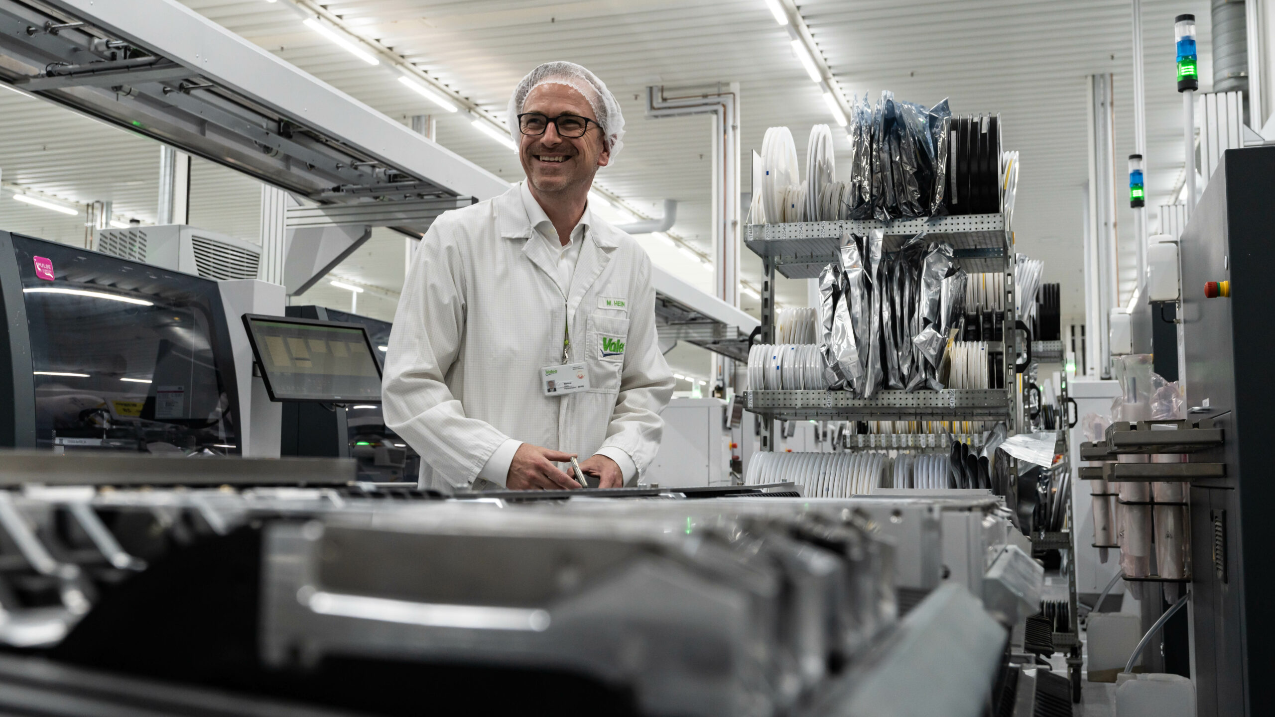 Un homme travaillant souriant devant un poste de travail