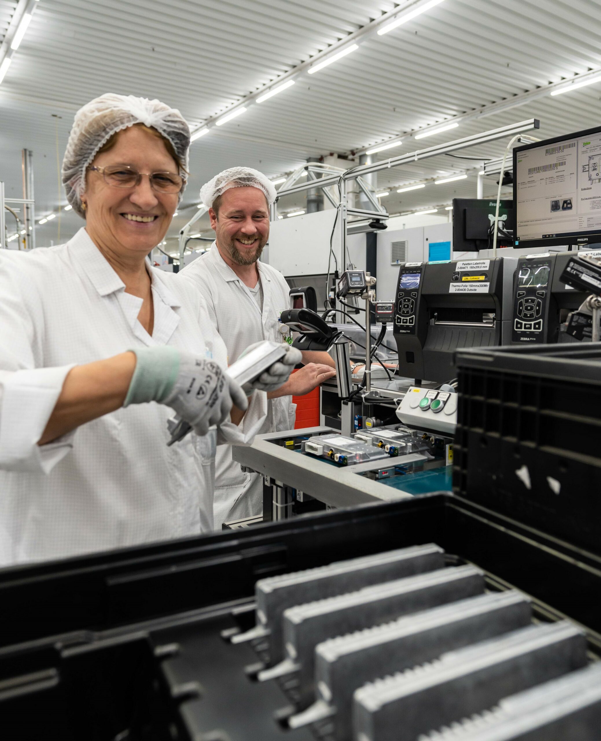 A worker woman and man smiling in a work station