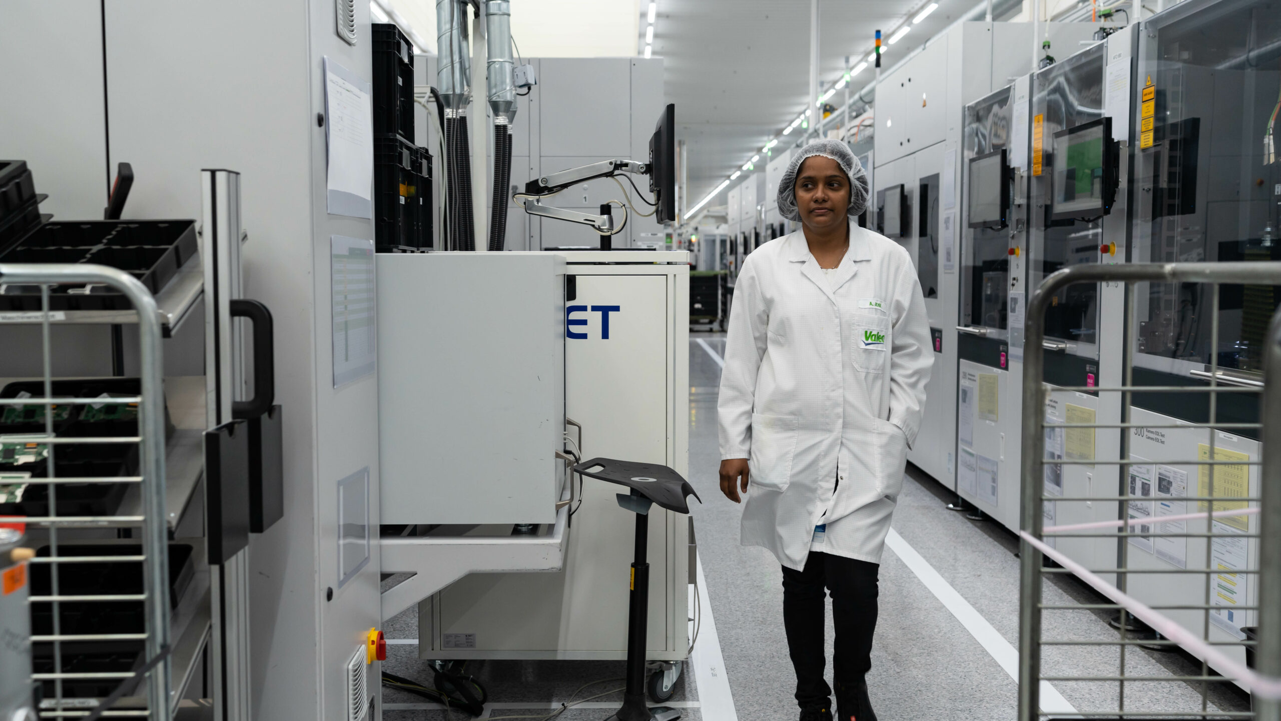 A woman walking on a corridor of a factory